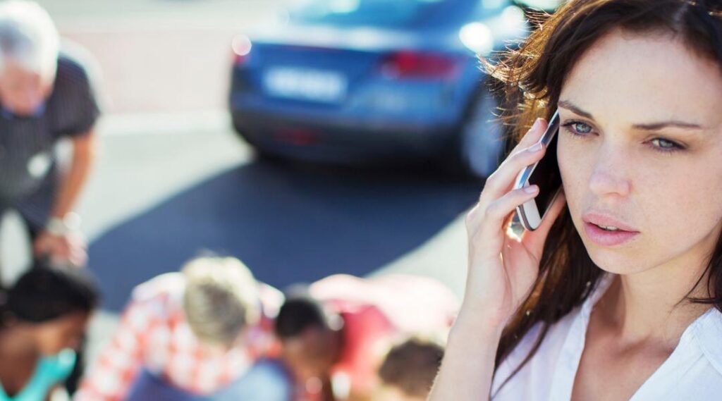 Concerned woman calling for help after a car accident, with auto accident attorneys assisting injured victims.