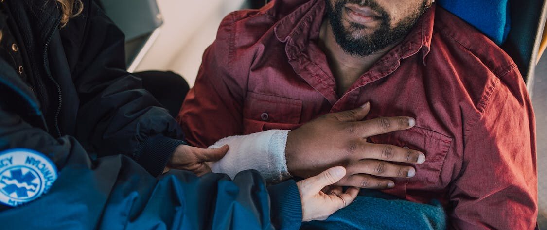 Injured man receiving medical attention in an ambulance after a car accident, seeking help from personal injury lawyers.