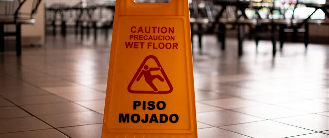 Caution wet floor sign indicating a hazardous area, emphasizing the need for a Slip and Fall Attorneys in case of injury.