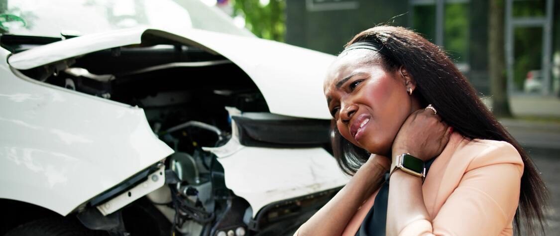Injured woman holding her neck after a car accident, seeking help from auto accident attorneys.